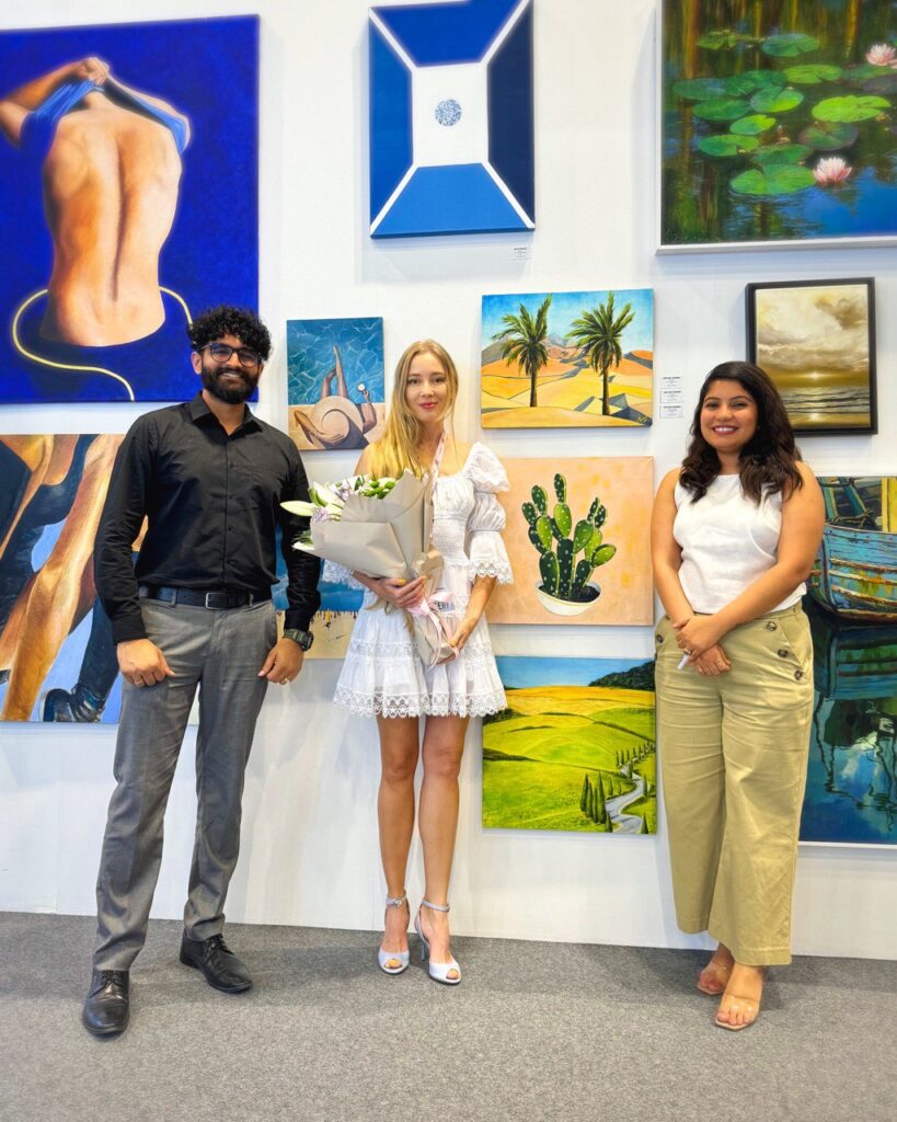 Lana Swan with visitors in front of her paintings at World Art Dubai 2024