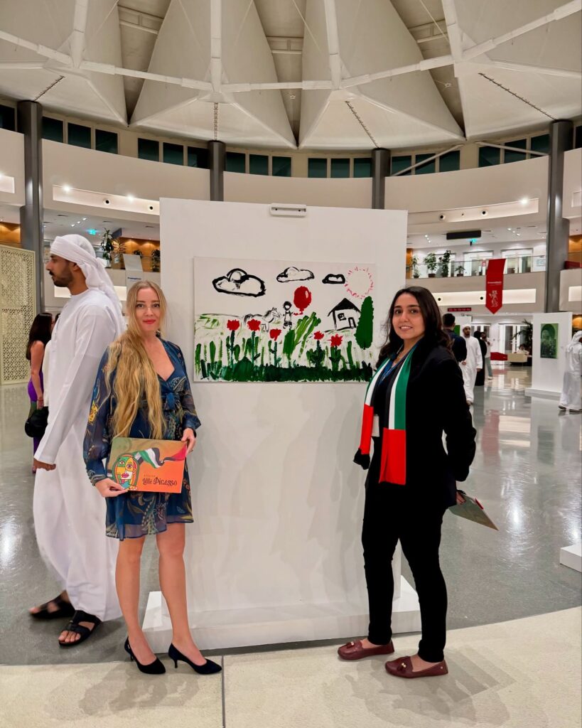 Lana Swan beside a children’s artwork at the Atelier Little Picasso Vernissage, Sorbonne University Abu Dhabi