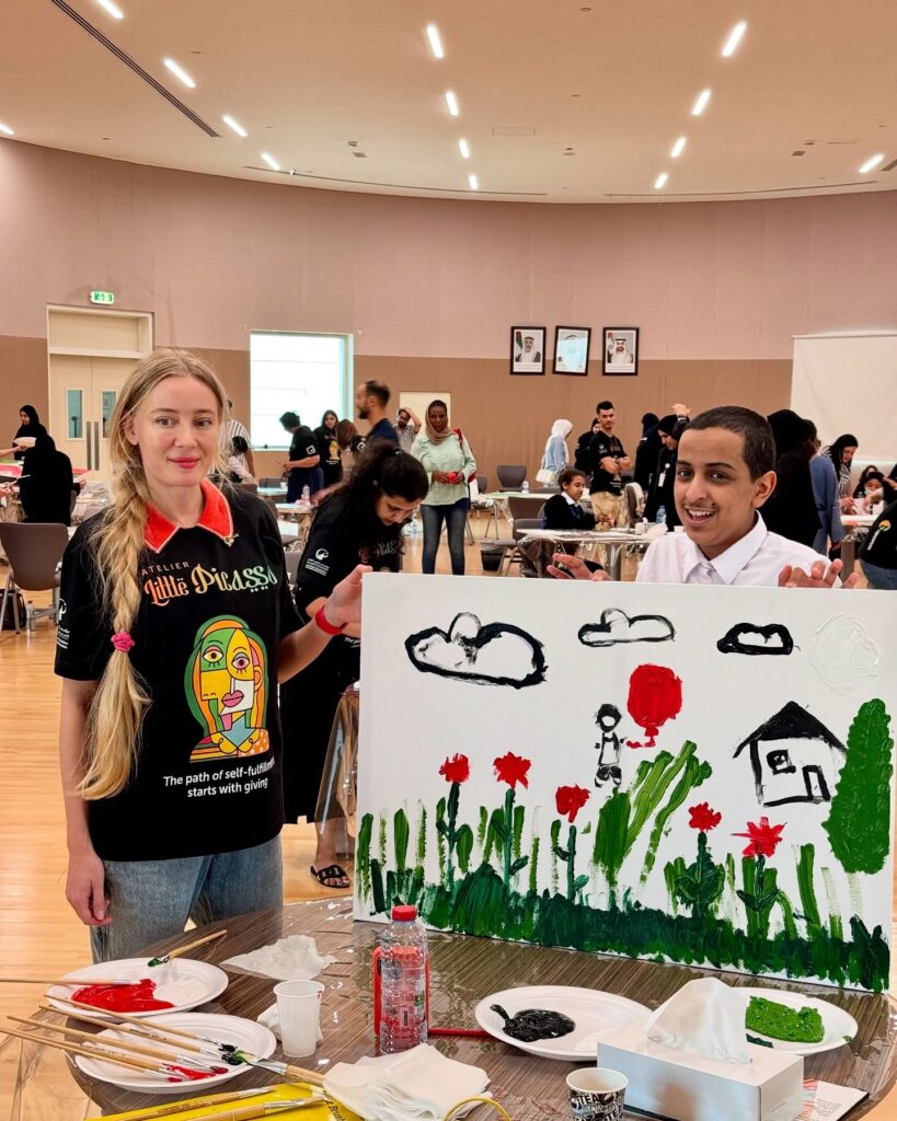 Lana Swan with a student and their painting at the Atelier Little Picasso workshop, Abu Dhabi